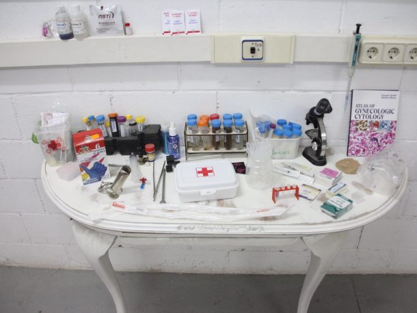 一张白色的桌子上摆满了医疗设备，包括一个急救箱和一个显微镜