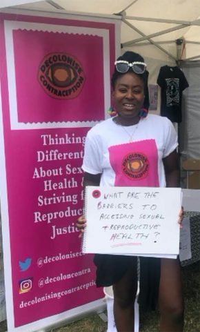 一个女人站在海报前促进生殖健康