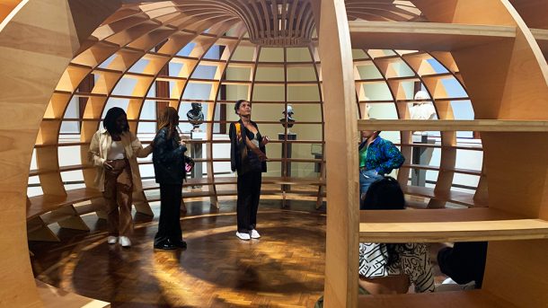 共同设计的成员在一个巨大的木制圆顶内抬头仰望