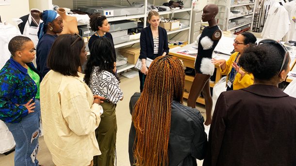 纺织品保育工作室的合作设计小组成员与保育员交谈。在他们面前有一个人体模型