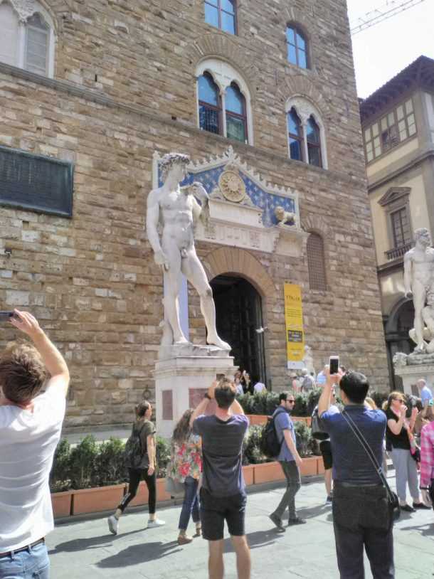 图12游客拍照的大理石Piazza della Signoria米开朗基罗的大卫,弗洛伦斯,2017年8月由古丽亚娜Videtta(图片)。